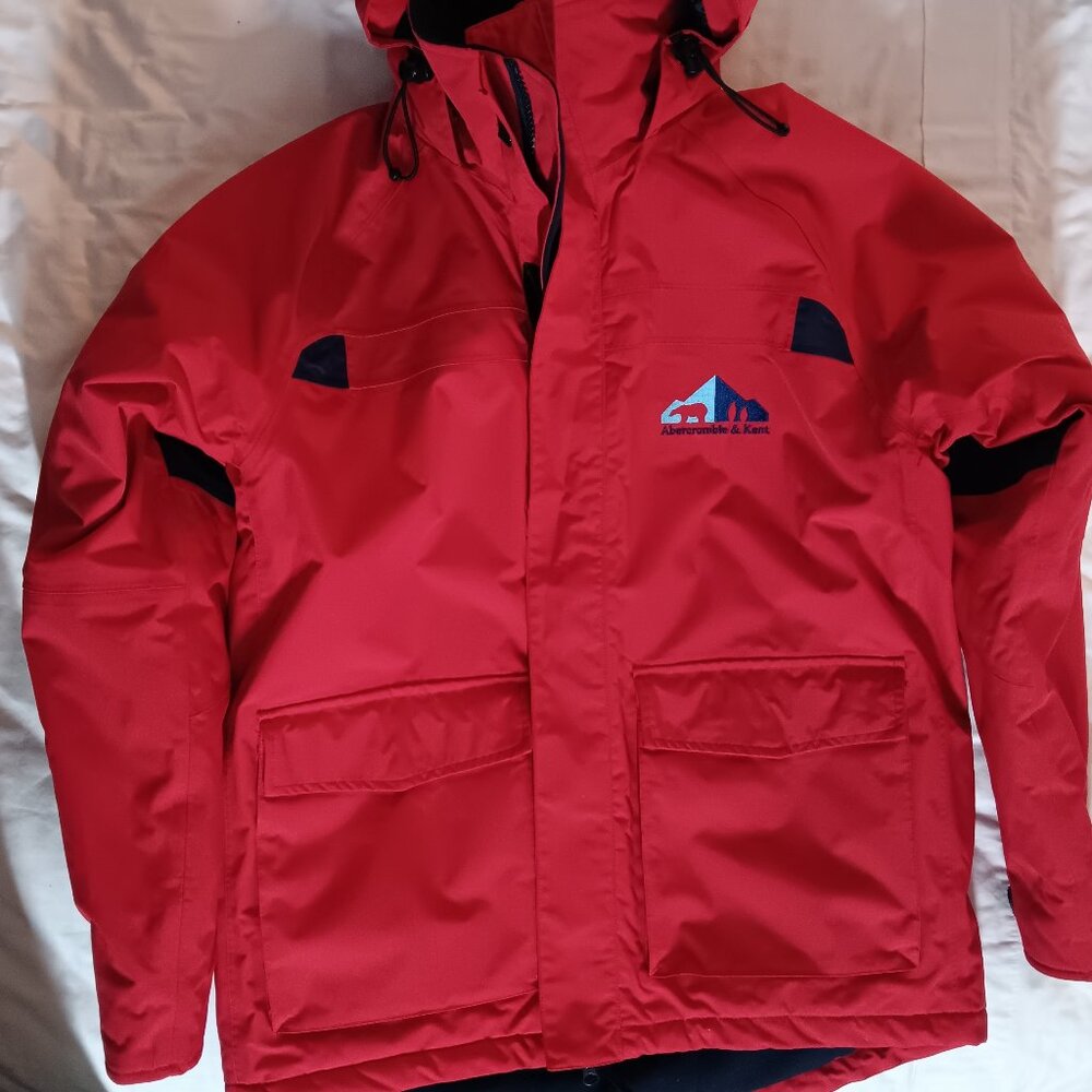 The iconic Abercrombie & Kent expedition red winter coat with blue lining.